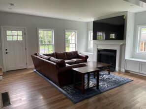 Den area with a beautiful leather couch and an 85" TV
