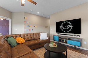 Upstairs living room holds a 75" TV with a Nintendo Switch.