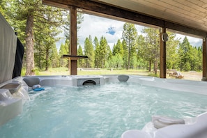 Relax in the steaming hot tub while taking in the peaceful forest scenery, the perfect way to unwind after a day of adventure.
