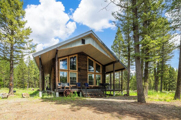 This stunning cabin blends modern design with rustic charm, featuring floor-to-ceiling windows, a spacious deck, and total seclusion on a peaceful 5-acre lot.