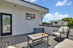 4th Floor: Private rooftop patio featuring outdoor lounging with a Smart TV for entertainment accompanied by gorgeous neighborhood views.