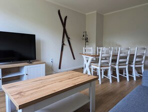 Modern eingerichtetes Wohnzimmer mit Sofa und Esstisch