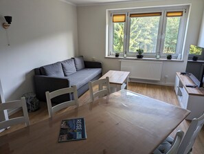 Modern eingerichtetes Wohnzimmer mit Sofa und Esstisch