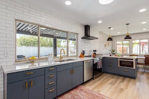 Fully equipped kitchen boasting stainless-steel appliances and stocked with all culinary essentials for ease and convenience during your stay.