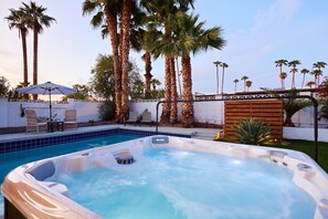 Private backyard featuring a pool, hot tub, BBQ grill, lounge chairs, mini golf, and a patio with a Smart TV, fire pit and outdoor dining area that seats 6 guests.
