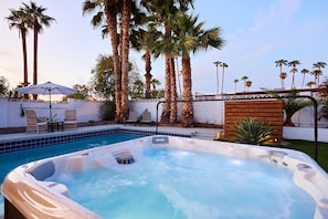 Private backyard featuring a pool, hot tub, BBQ grill, lounge chairs, mini golf, and a patio with a Smart TV, fire pit and outdoor dining area that seats 6 guests.