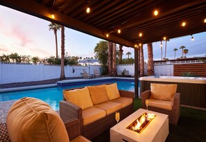 Private backyard featuring a pool, hot tub, BBQ grill, lounge chairs, mini golf, and a patio with a Smart TV, fire pit and outdoor dining area that seats 6 guests.