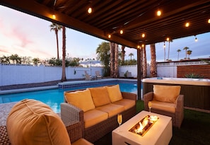 Private backyard featuring a pool, hot tub, BBQ grill, lounge chairs, mini golf, and a patio with a Smart TV, fire pit and outdoor dining area that seats 6 guests.