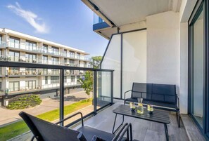 Umeblowany balkon z widokiem na wewnętrzny dziedziniec. 