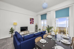 Dining table positioned near large windows, allowing for scenic meals
