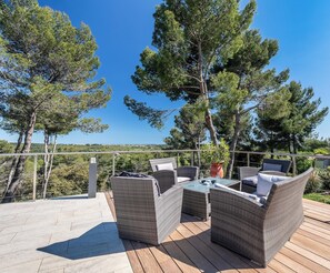 deck setting, view of swimming pool, pine forests and out to the sea!