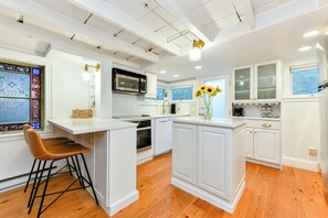 Antique cottage with stain-glass window and a stainless kitchen.