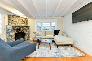 Living room with smart TV and decorative fireplace.
