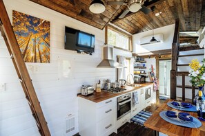 ROKU TV mounted on the wall, fully stocked kitchen, & stairs to the master loft.