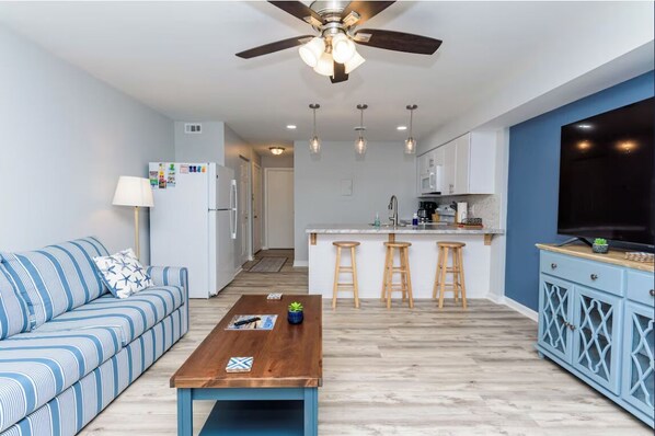 Living room with view into kitchen
