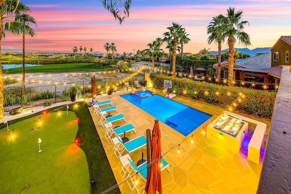 Second floor view of the backyard with panoramic vistas, and a resort-style oasis complete with saltwater pool and spa and sun shelf, putting green, fire pit, and custom mist system and pool fogger.