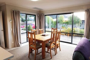 Dining room with a view of the lovely outdoor patio.  Curtains all fully close while still allowing ambient light inside.