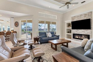 Large, bright, open living area features ample seating, fireplace and 65-inch Smart TV
