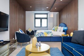 Integrated living, bedroom, and kitchen spaces in an open layout.
