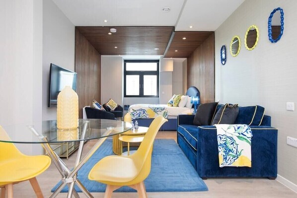 Integrated living, bedroom, and kitchen spaces in an open layout.