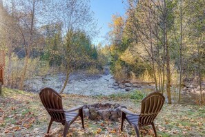 Now that’s a cozy riverside setup—two chairs by a fire pit, the perfect spot for morning coffee or stargazing with the sound of the river as your soundtrack. Pure peace.