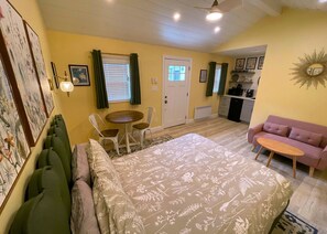 Petite studio layout- Queen bed table for two, sofa, kitchenette, exterior door 