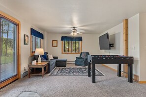 This space is designed for ultimate relaxation and entertainment, featuring a large TV and a classic foosball table.