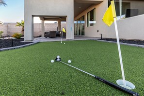 Putting green with putters and balls.