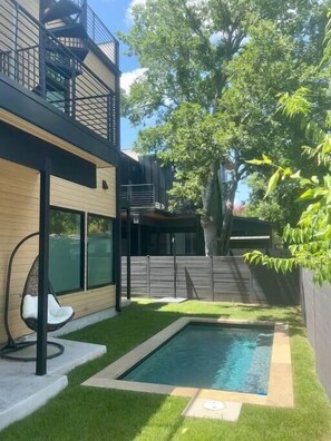 The backyard houses a 8’x16’ heated in-ground salt water pool with a built in seating area for up to 10 guests and an outdoor shower.