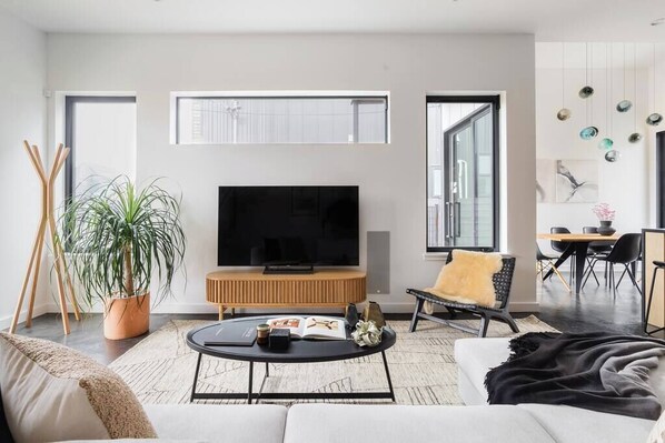 The downstairs living room is furnished with a large, cozy, and comfortable sectional, an accent chair, a 65" smart flat screen TV, and integrated architectural audio with an in-wall subwoofer.