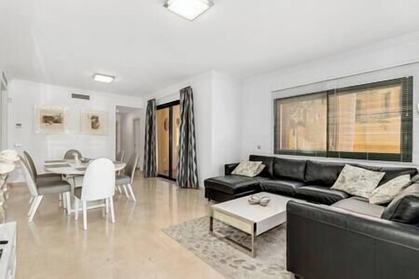 Modern and elegant living-dining room, with a big sofa, Smart Tv and coffe table (1)
