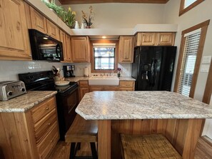 Kitchen with stove, oven, microwave, fridge, and all the cooking utensils