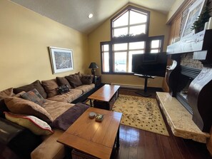 Large, cozy living room with propane fireplace and large smart TV with soundbar