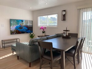 Contemporary living room with 75" smart TV and luxurious leather sectional sofa.