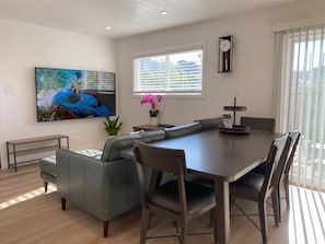 Contemporary living room with 75" smart TV and luxurious leather sectional sofa.