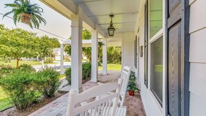 Enjoy the tranquility of this shaded front porch, complete with rocking chairs and lush landscaping.