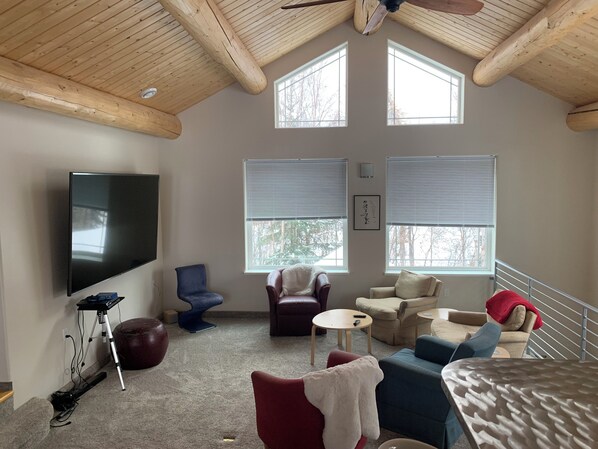 Comfy chairs, an 86 inch TV screen, make for a great home entertainment.