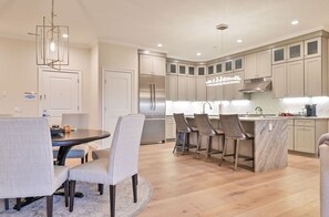 Modern kitchen and dining area featuring high-end appliances, elegant decor, and ample seating for meals and gatherings.