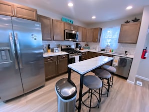 Full kitchen w/ fridge, microwave, stove, dishwasher, coffee maker, & essentials
