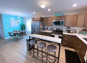 Full kitchen w/ bar seating & dining area