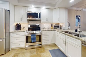 Fully equipped kitchen with modern appliances, including a refrigerator, stove, microwave, and dishwasher.