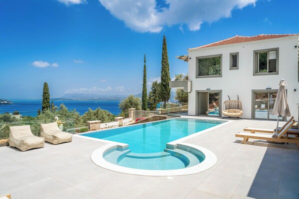 Outdoor swimming pool area with jacuzzi and barbeque offering amazing sea views