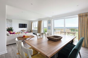 Dining table seating area and living room area overlooking the garden and sea view 