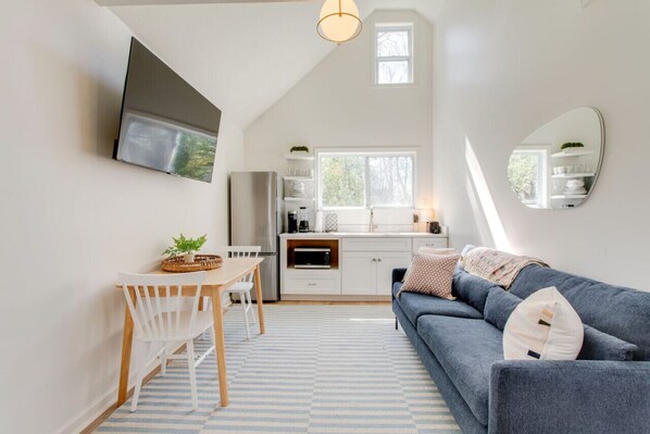 The living room with a smart T.V. and a kitchenette.