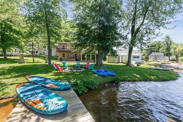 Enjoy a lakefront oasis with a hot tub, fire pit, grill, kayaks, and paddleboard