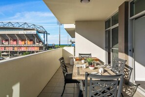 Dine outside on the covered balcony, taking in glimpses of the ocean and WIN Stadium.
