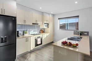 The spacious kitchen makes cooking a breeze with high-quality appliances and plenty of shops close by.
