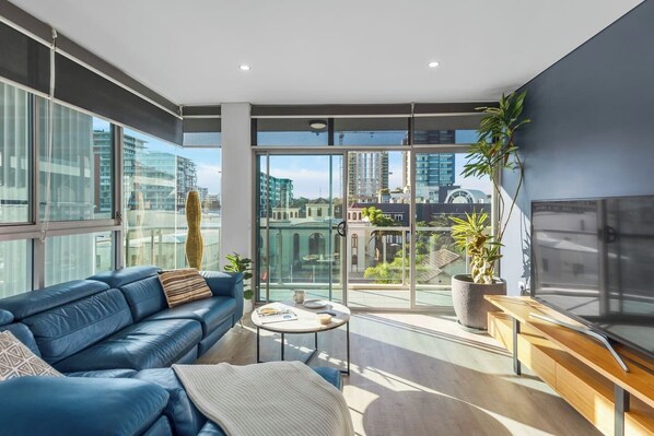 With full-height glass windows, the living room is bathed in natural light and boasts gorgeous skyline views.
