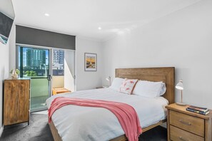 The primary bedroom highlights a king-sized bed and opens straight to the balcony.
