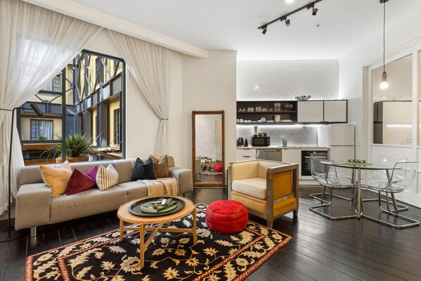 Spacious and light-filled lounge with modern kitchen and cozy seating – ideal for families or couples.